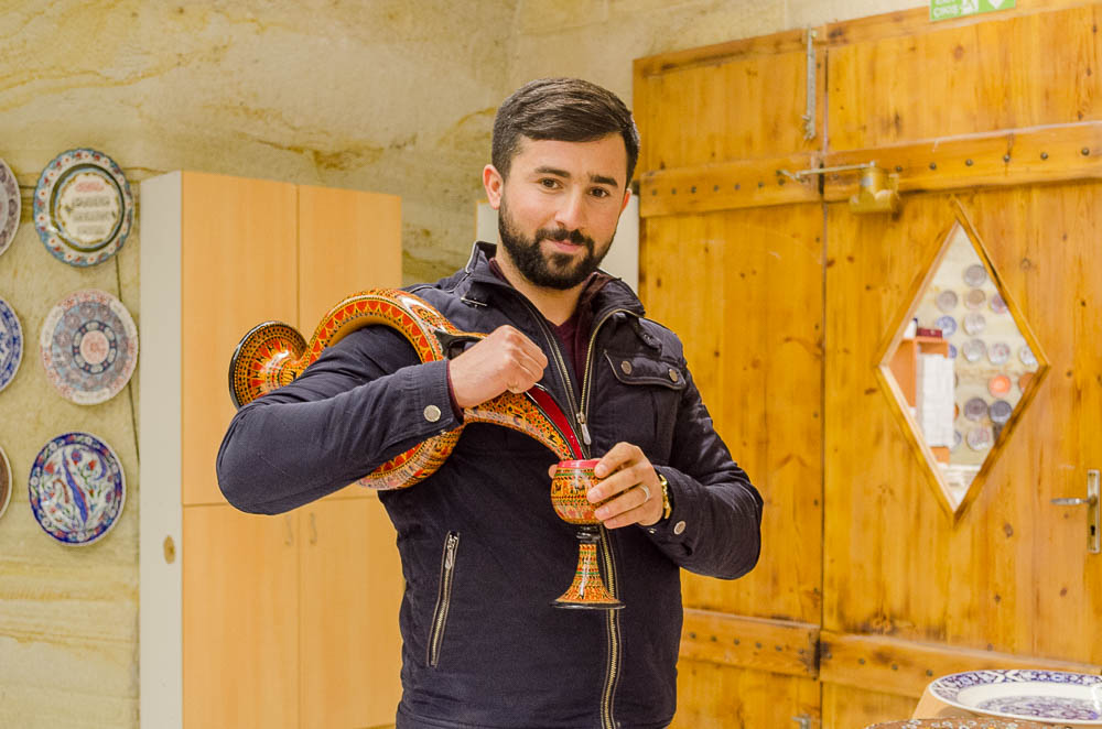 Türkischer Guide führt die Weinkaraffe aus Keramik vor